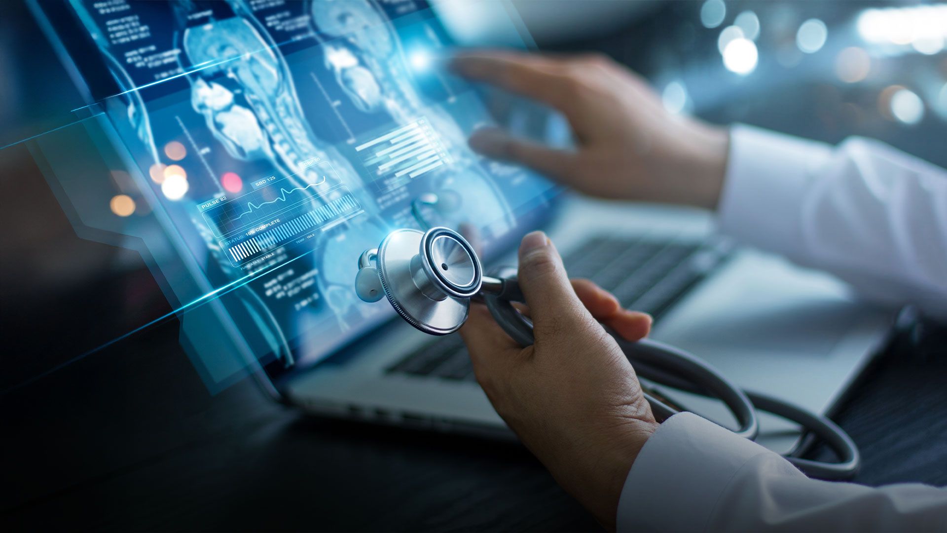 Arzt hält Stethoskop und interagiert mit digitalen medizinischen Bilddaten auf einem Laptop