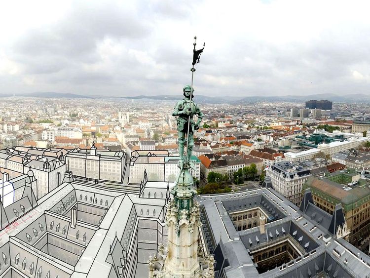 Blick auf eine Stadt mit einer Statue auf einem Turm, die Statue zeigt eine Figur mit einer Fahne, im Vordergrund sind gezeichnete Umrisse von Gebäuden zu sehen