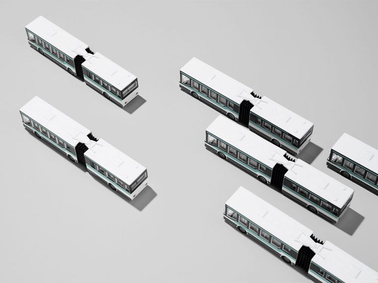 Sechs weiße Gelenkbusse mit schwarzen Verbindungsstücken, von oben auf grauem Untergrund angeordnet