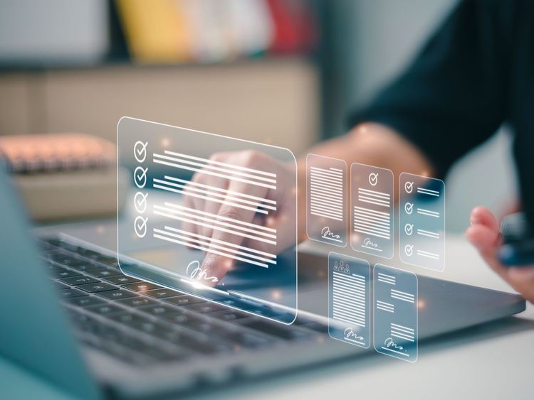 Hand tippt auf Laptop-Tastatur mit schwebenden digitalen Dokumenten und Checklisten